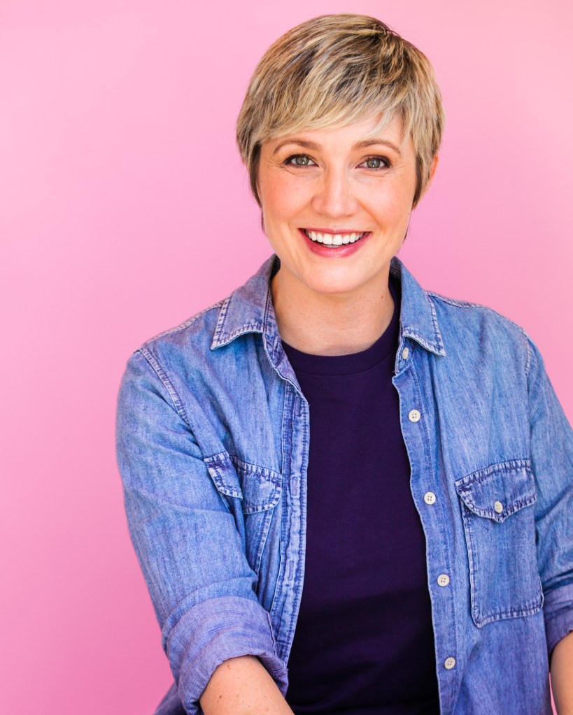Image of Athena Ever creator of The Ever Method™ wearing a blue jean shirt on bubblegum pink backdrop.